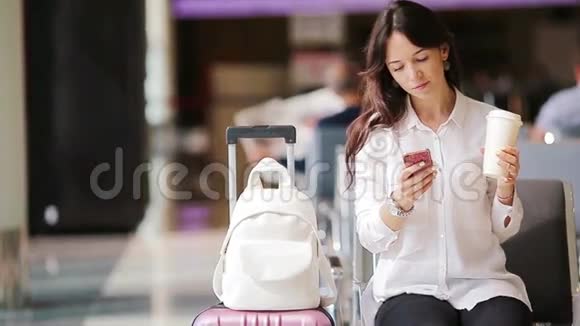 航空公司乘客在机场休息室等待航班飞机带智能手机的白人女人在候诊室视频的预览图