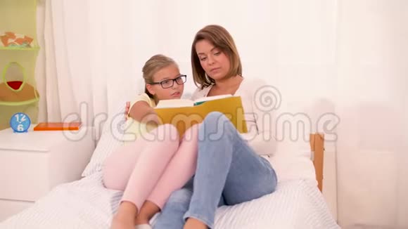 快乐的女孩和妈妈在家看书视频的预览图