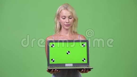 年轻快乐美丽的女商人展示笔记本电脑视频的预览图