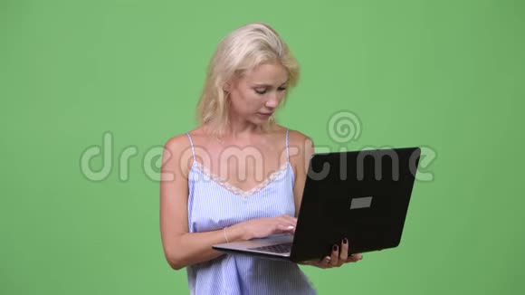 年轻快乐的漂亮女商人用笔记本电脑思考视频的预览图