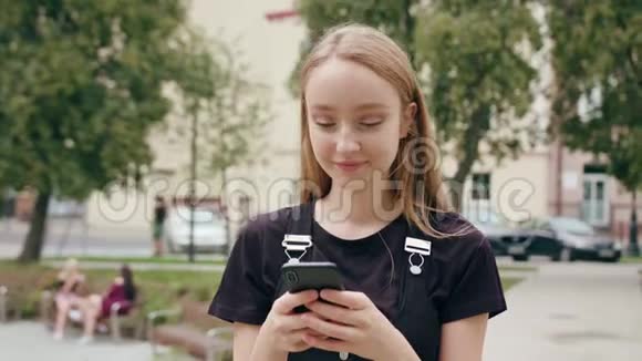 年轻的红头发女士在城里用电话视频的预览图