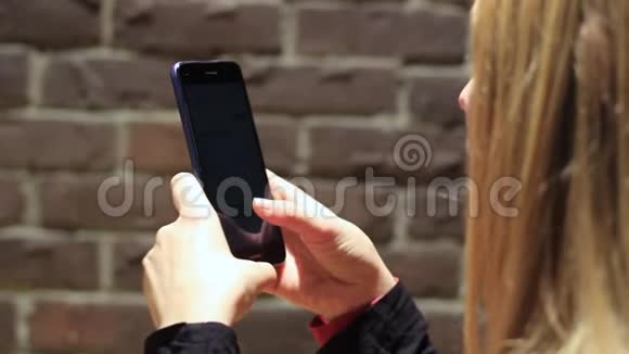 用手机握手女孩用智能手机视频的预览图