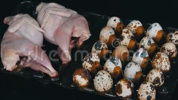 新鲜的鹌鹑肉放在一个塑料棕色托盘旁边的鹌鹑蛋黑色背景视频的预览图