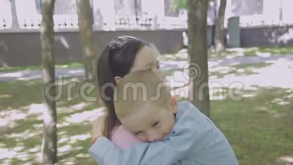 一家人带着孩子在公园散步晴天绿树树视频的预览图