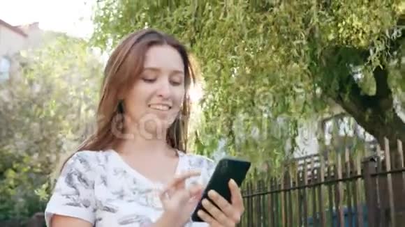 年轻女士在城里散步时用电话视频的预览图