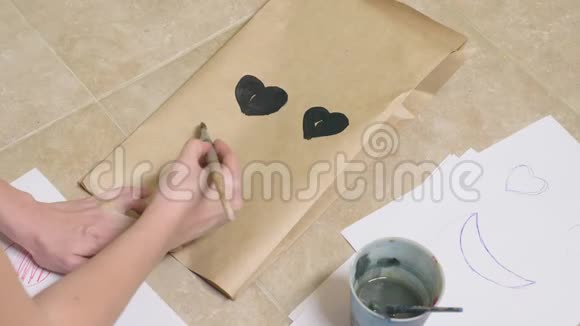 女孩用画笔在纸袋上画出各种情感微笑中的情感概念视频的预览图