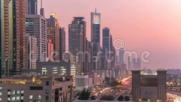 迪拜市中心的塔楼日夜不停日落后带摩天大楼的谢赫扎耶德公路的鸟瞰图视频的预览图