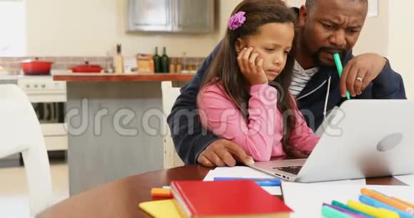父亲和女儿使用笔记本电脑4k视频的预览图