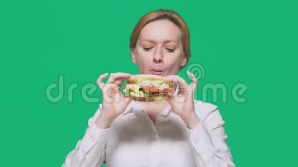 商业女性在绿色背景下吃三明治快速午餐概念视频的预览图