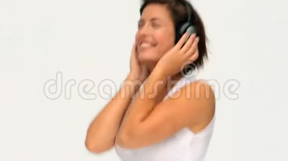 可爱的黑发女人带着耳机听音乐视频的预览图