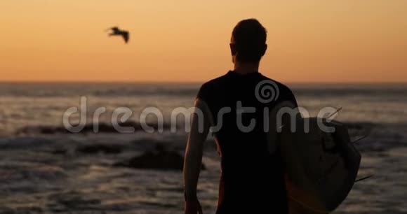 站在沙滩上冲浪板的人视频的预览图