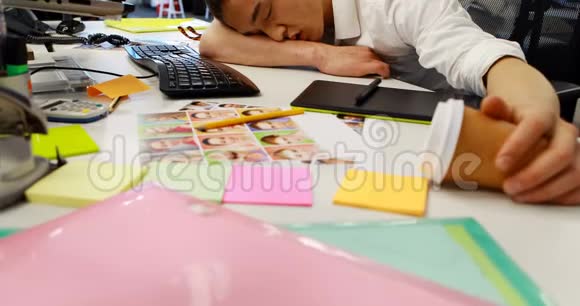 男性平面设计师睡在桌子上视频的预览图
