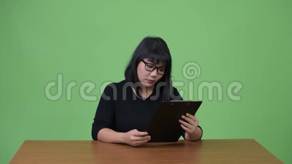 美丽的亚洲女商人一边思考一边剪贴板视频的预览图