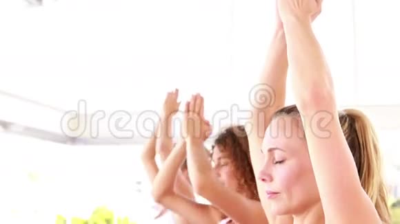微笑着站在瑜伽位置的运动女性视频的预览图