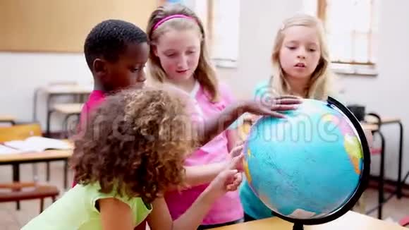 微笑的孩子们看着地球仪视频的预览图