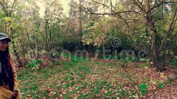 女孩走在秋天五彩缤纷的美丽森林里视频的预览图