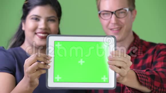 年轻的多民族商业夫妇在绿色背景下在一起视频的预览图