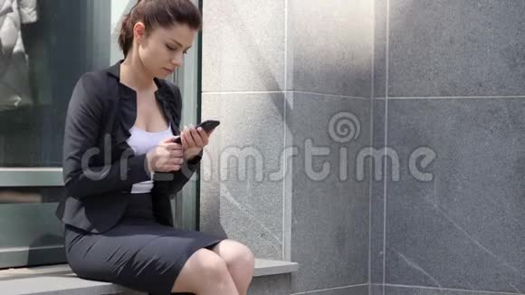 商界女性忙于使用智能手机视频的预览图