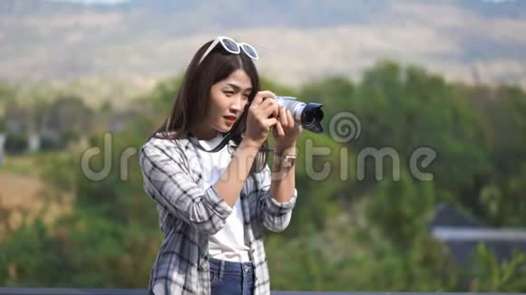 在大自然中用照相机拍照的女游客视频的预览图
