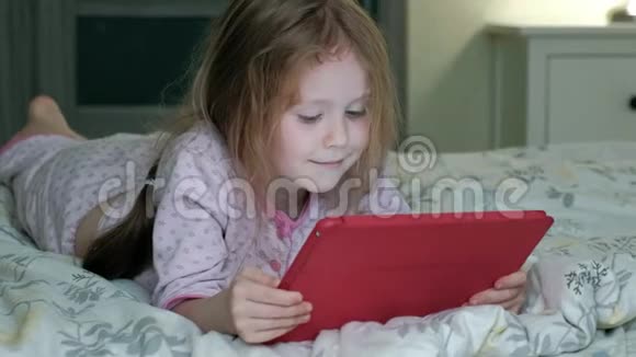 在床上玩平板电脑的小女孩视频的预览图