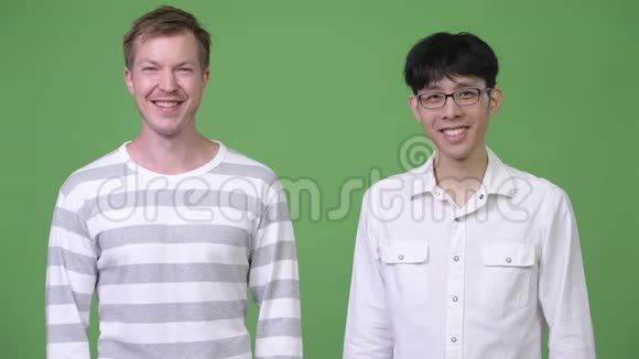 两个多民族的年轻商人在绿色的背景下一起微笑视频的预览图