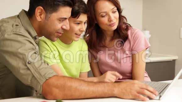 父母使用笔记本电脑他们可爱的儿子视频的预览图