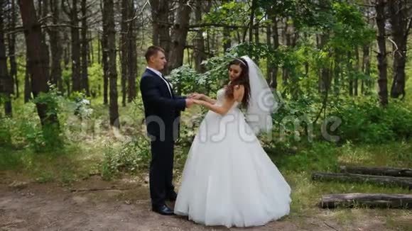 新郎新娘在树林里摆姿势视频的预览图