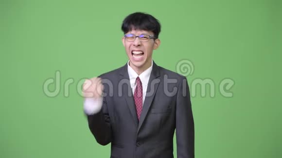 年轻快乐的亚洲商人微笑着举起拳头视频的预览图