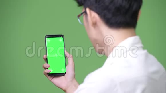 年轻的亚洲商人用手机显示复印空间视频的预览图