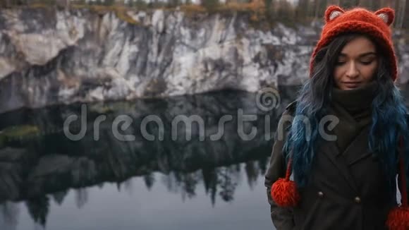 漂亮的女孩喜欢美丽的湖景从山上和良好的天气在卡雷利亚在岩石周围视频的预览图