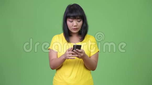 美丽的亚洲女人在电话中思考视频的预览图