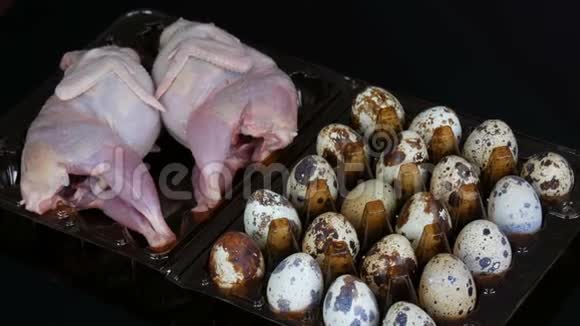 黑色鹌鹑蛋旁边的塑料棕色托盘中鹌鹑的新鲜肉视频的预览图