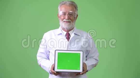绿色背景下英俊的大胡子男医生视频的预览图