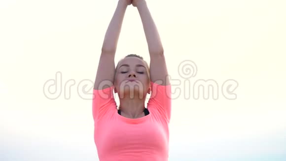 健康年轻的美女冥想日出时在海边练习瑜伽做平衡和平衡的练习视频的预览图