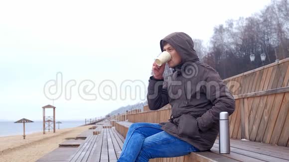 浪漫的年轻人在海滩上放松喝热茶或热水瓶咖啡平静舒适的夜晚视频的预览图