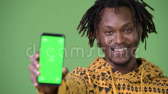 年轻快乐英俊的非洲男人带着手机微笑视频的预览图