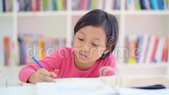 在图书馆桌子上学习的小女孩视频的预览图