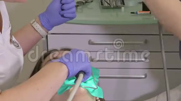 牙医诊所的妇女得到牙科治疗以填补牙齿的空洞牙科修复和复合材料视频的预览图