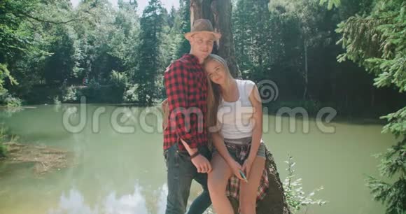 美丽的白种人夫妇在阳光明媚的日子里在森林里度过时光的肖像视频的预览图