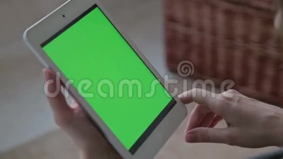 女子观看绿屏平板电脑视频的预览图