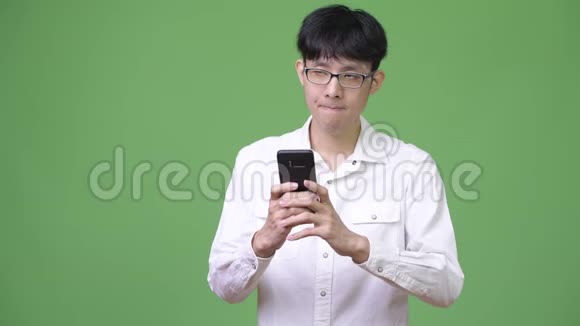 年轻的亚洲商人用电话思考视频的预览图