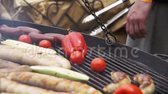 在烧烤炉上准备烧烤美味的香肠和蔬菜慢动作视频的预览图