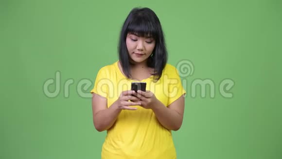 美丽快乐的亚洲女人用电话视频的预览图