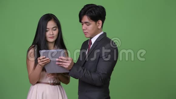 年轻的亚洲商务夫妇在绿色的背景下在一起视频的预览图