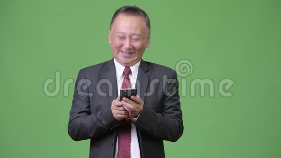 成熟的日本商人使用电话视频的预览图