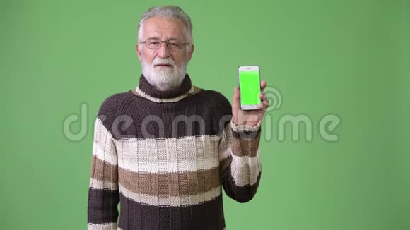 身穿绿色背景暖衣的英俊的大胡子男子视频的预览图