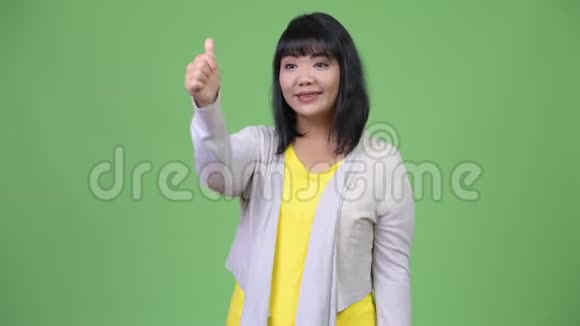 美丽快乐的亚洲女人微笑着竖起大拇指视频的预览图