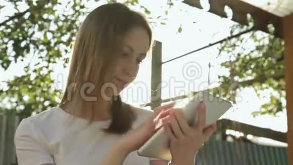 女人在日落时使用平板电脑视频的预览图