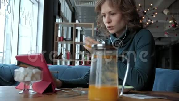 咖啡馆里有平板电脑的迷人年轻女性自由职业者的概念视频的预览图