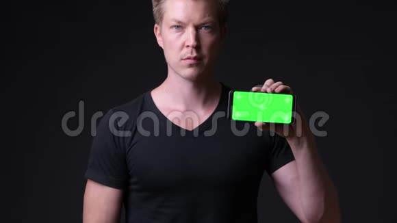 年轻的帅哥用手机用绿色屏幕色键视频的预览图